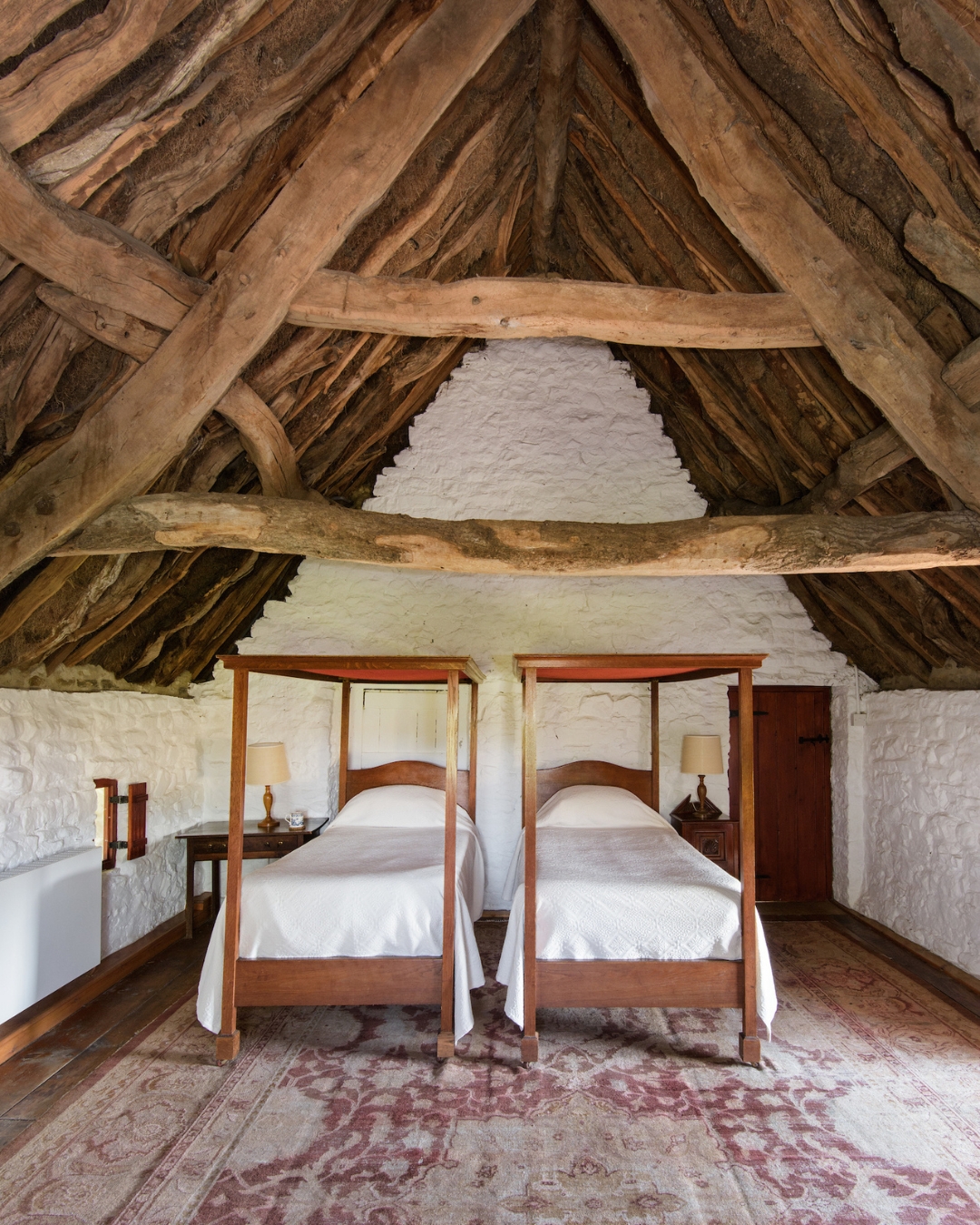 A twin bedroom with a timber beamed celing