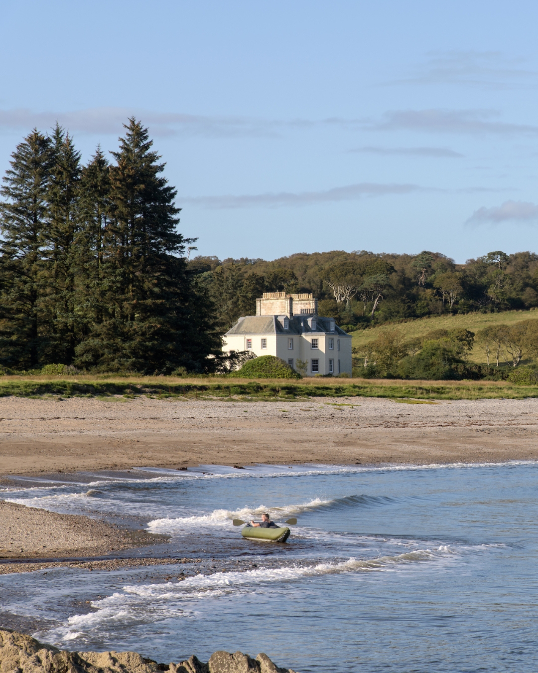 A large white house sitting on a beach