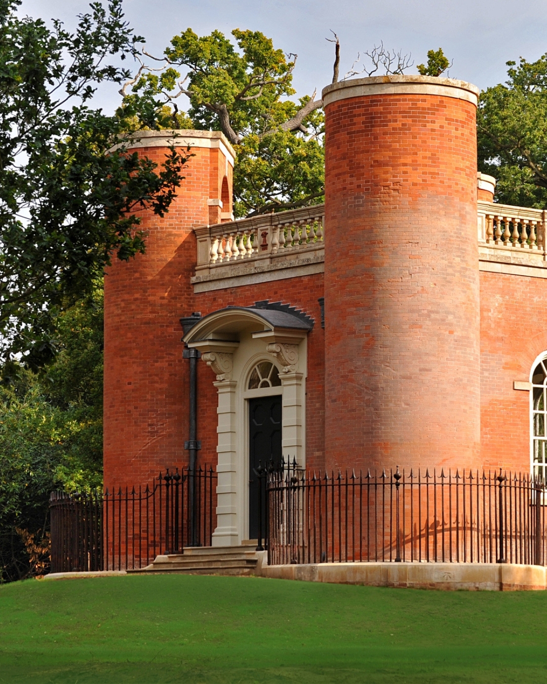 A pink folly surrounded by woodland