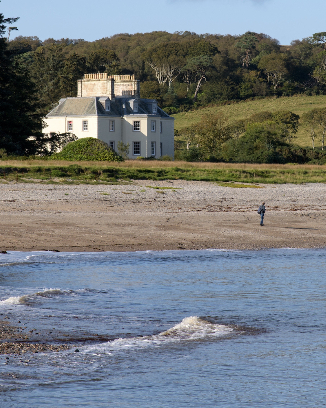 Large white house on a beach overlooking the sea