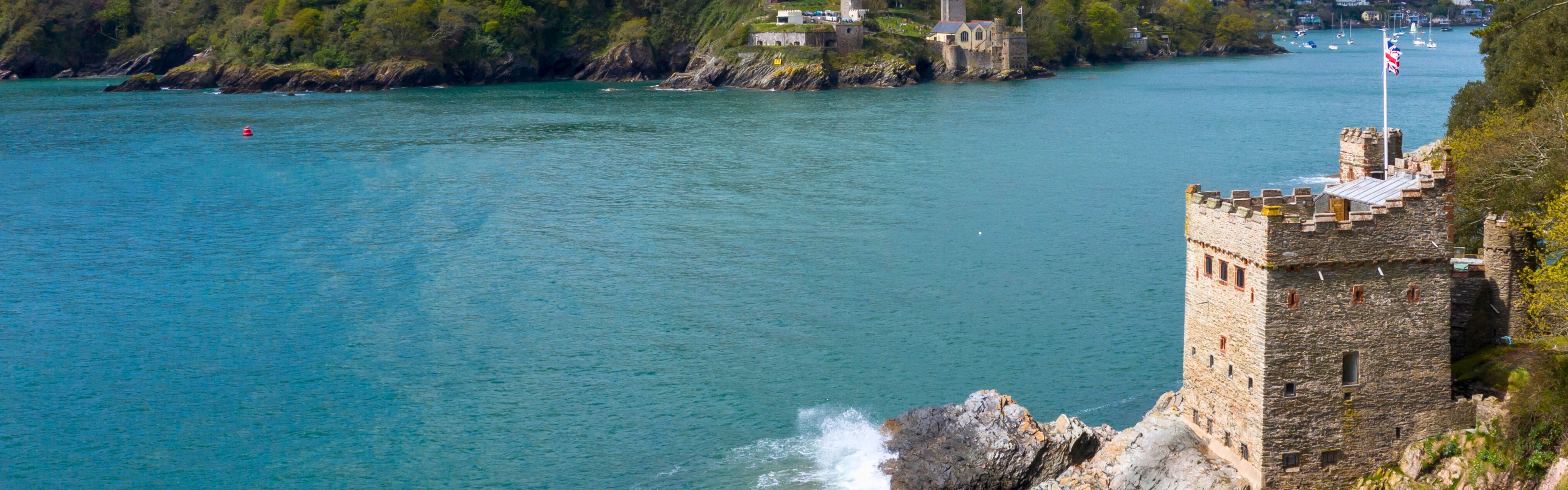 A small castle on a rocky outcrop in a river estuary