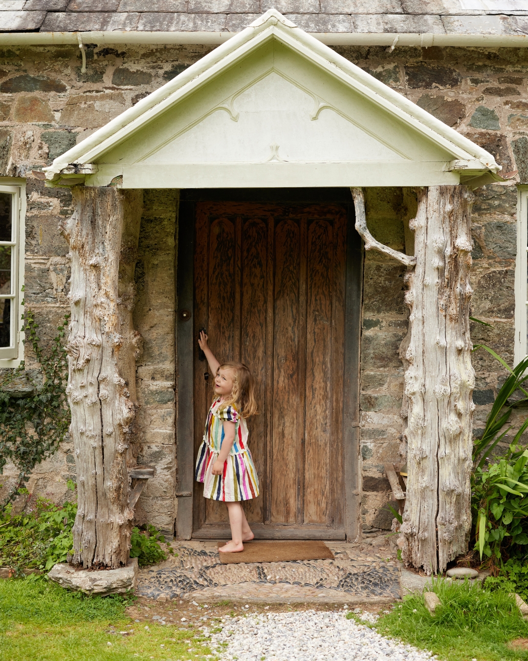 Child knocking on a door of a cottage