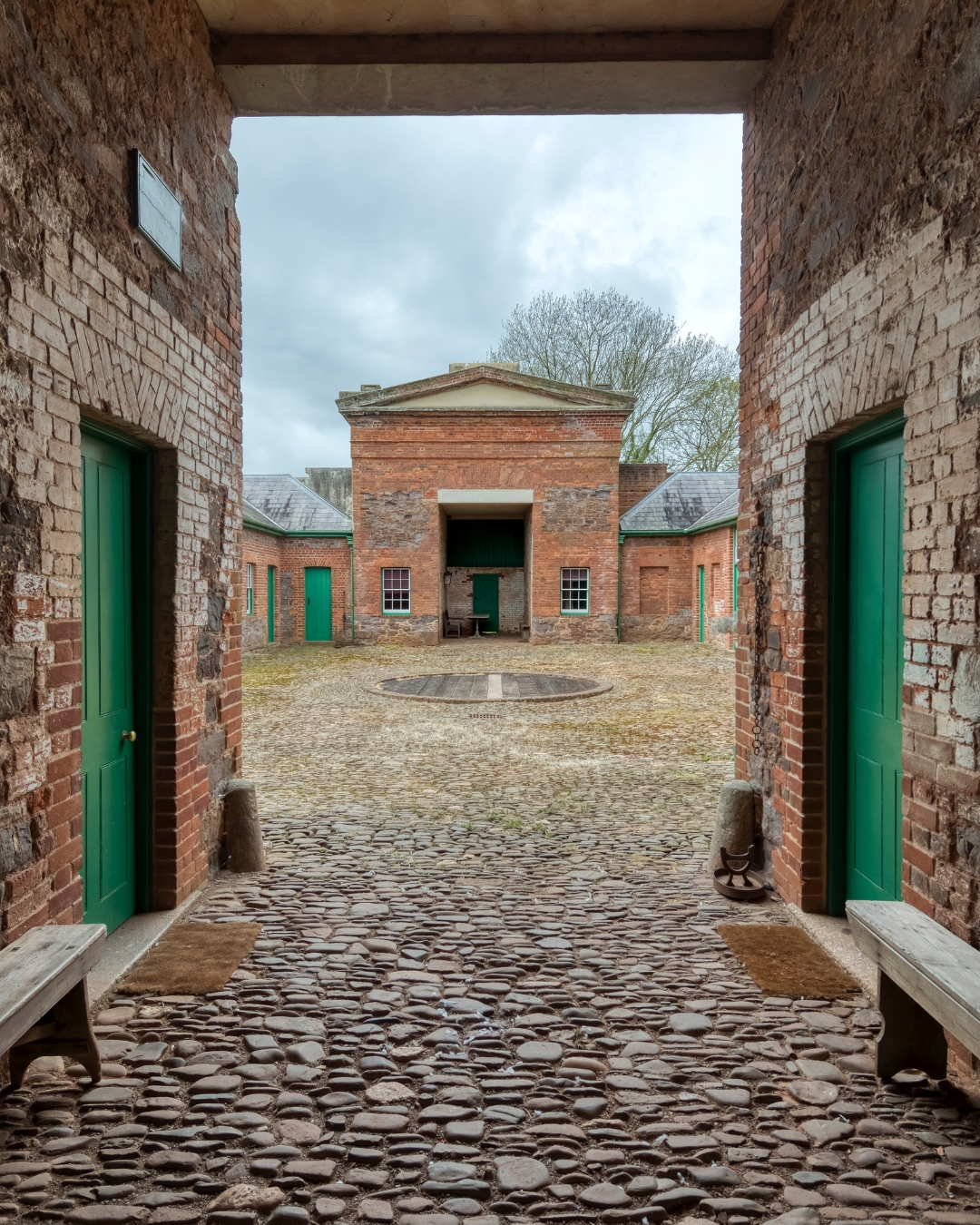 The courtyard of a Victorian stable block, looking through a gateway