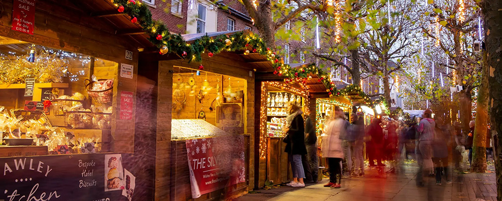 York Christmas market chalets with lights and shoppers 